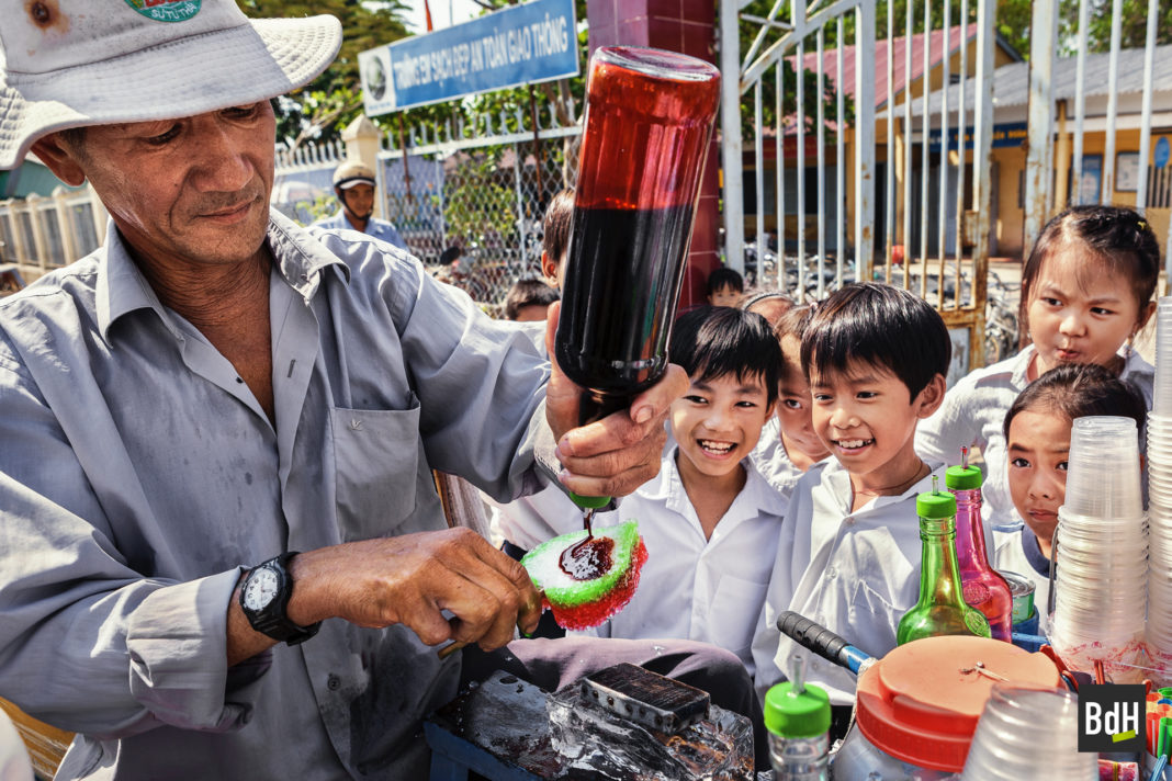 Marchand de glaces à la sortie d'une école primaire sur la route QL54 entre Can Tho et Sa Dec, Delta du Mékong, Cochinchine, Vietnam