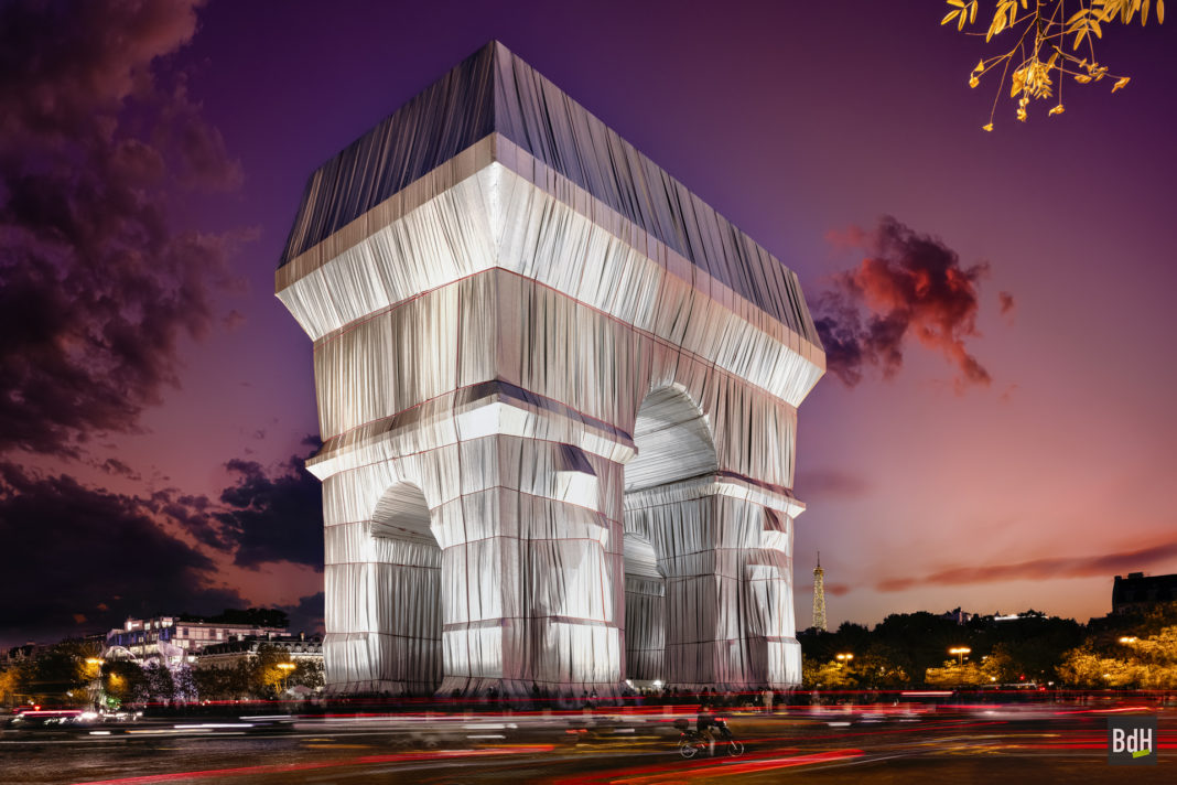 L'Arc de Triomphe emballé par Christo et la Tour Eiffel à la tombée de la nuit le 24 septembre 2021 à Paris, France.