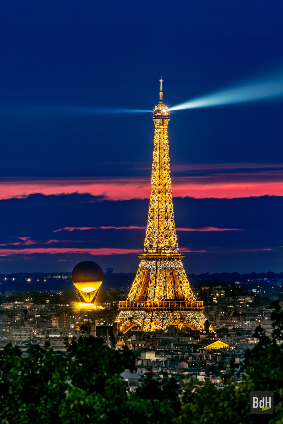 Tour Eiffel et la vasque olympique au coucher de soleil. Elle s'élève au dessus du jardin des Tuileries à 30 mètres. L'anneau contient la flamme, faite d'eau et de lumière 100% électrique, créée par le designer Mathieu Lehanneur